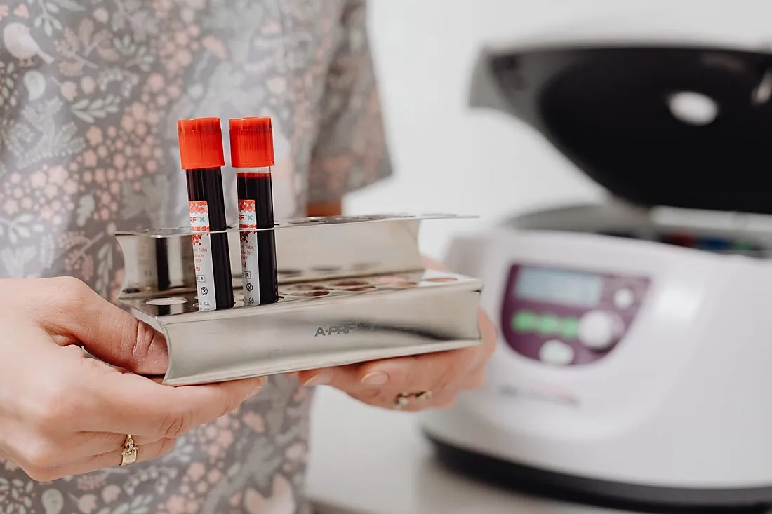 a researcher holding blood sample vials in a lab