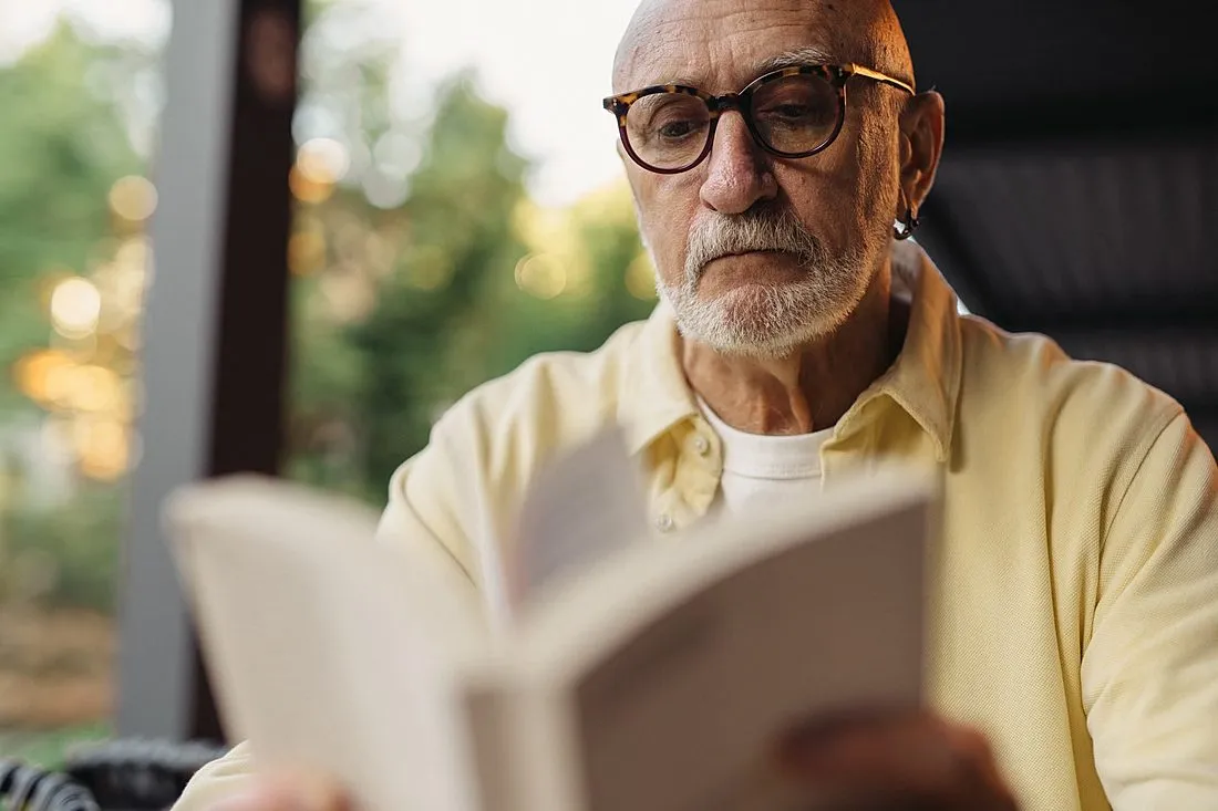 an older adult reading a book