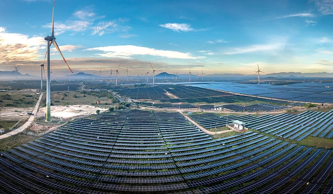 wind turbines and solar panels at sunset