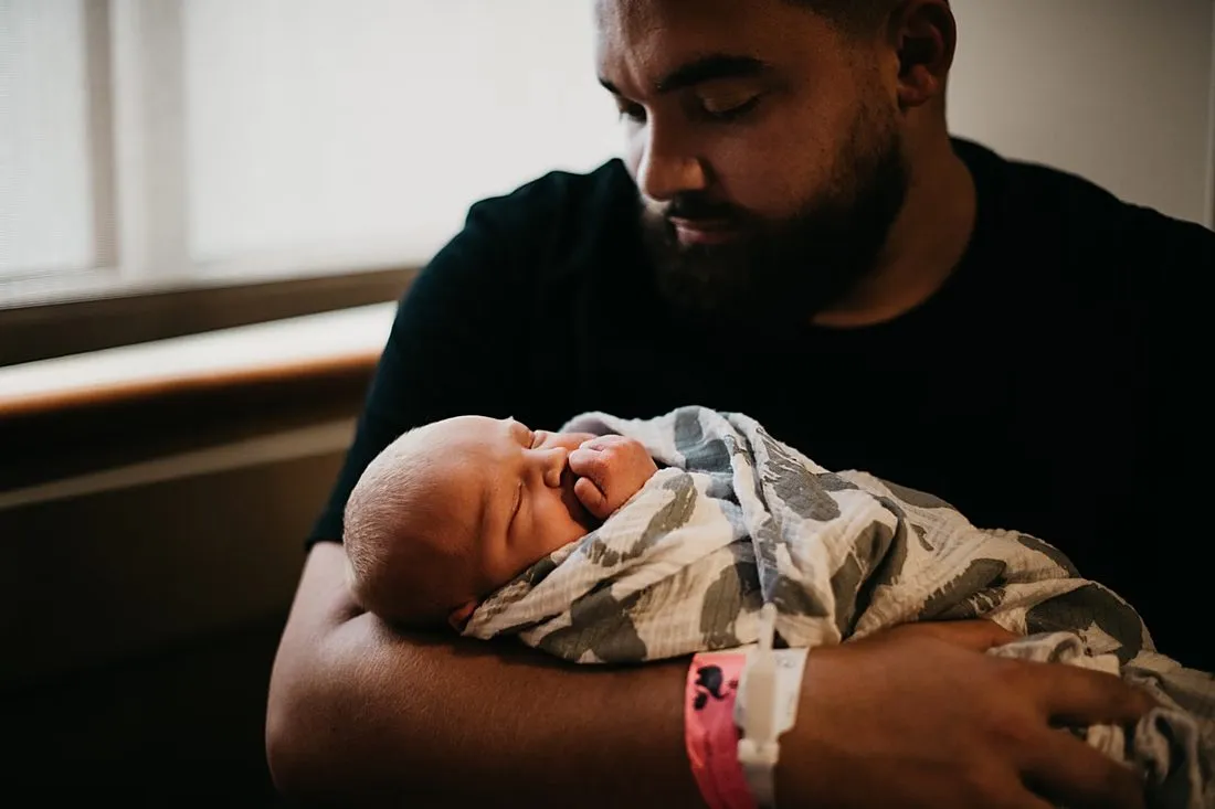 an elderly man holding a newborn baby
