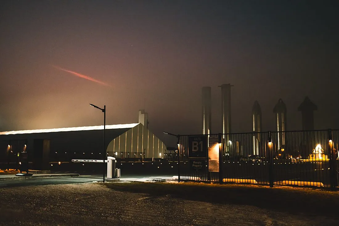 a rocket launching from a coastal spaceport at night