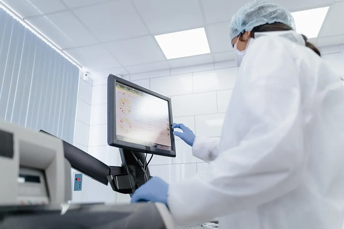 a scientist examining DNA sequencing data on a lab monitor