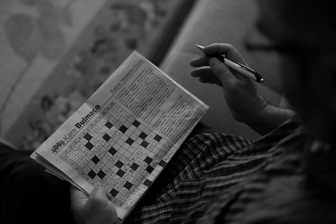 an active older woman doing a crossword puzzle