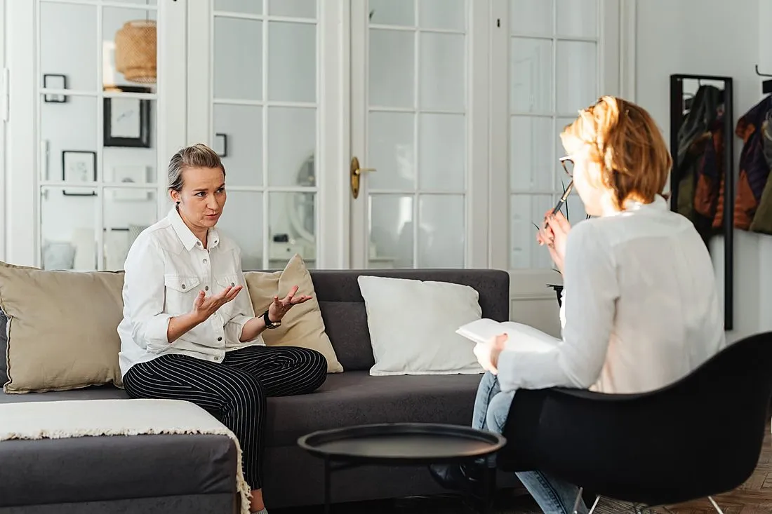 a therapist and client talking in a warm counseling room