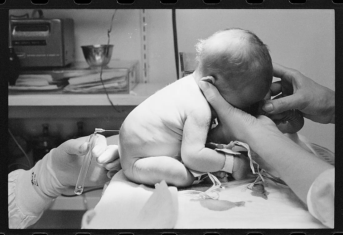 newborn baby being held by a parent