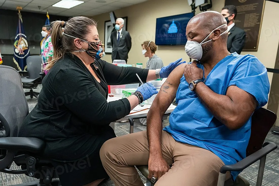 doctor administering vaccine to patient