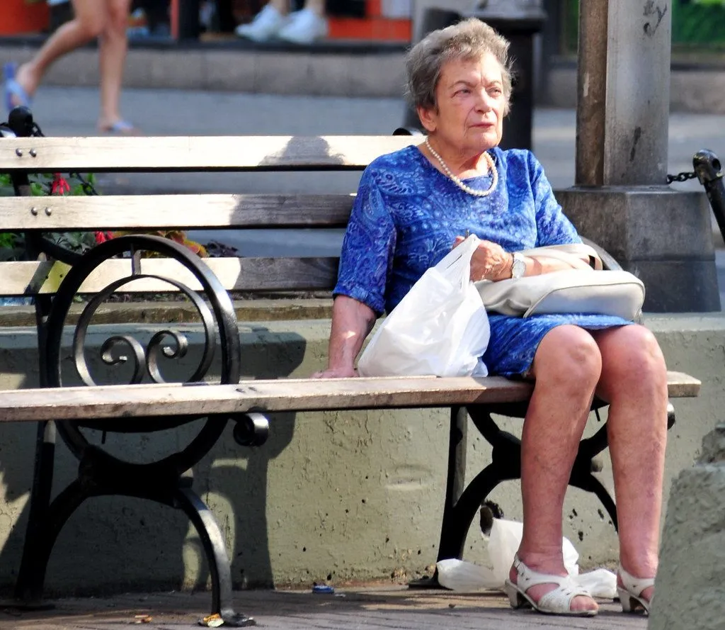 elderly woman sitting alone at a window