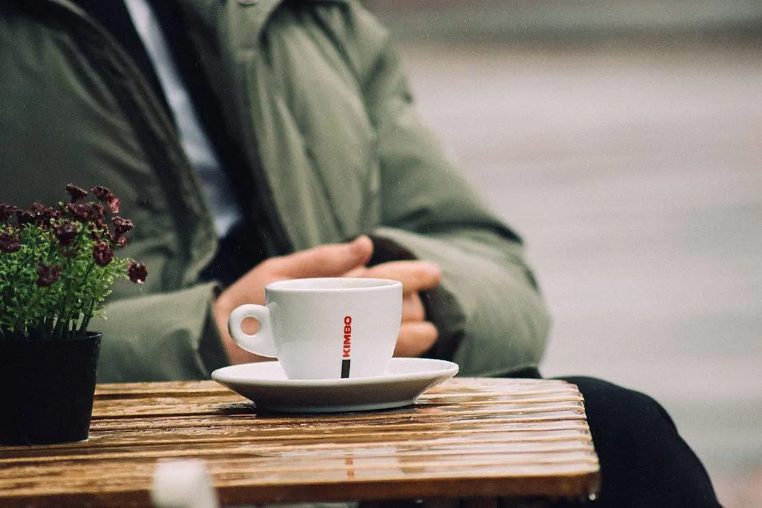 a person drinking coffee at a cafe table