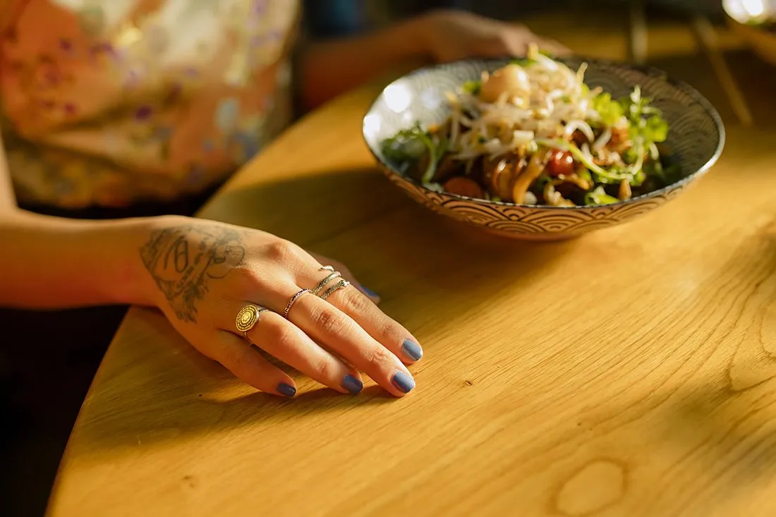 a person eating a meal at a wooden table